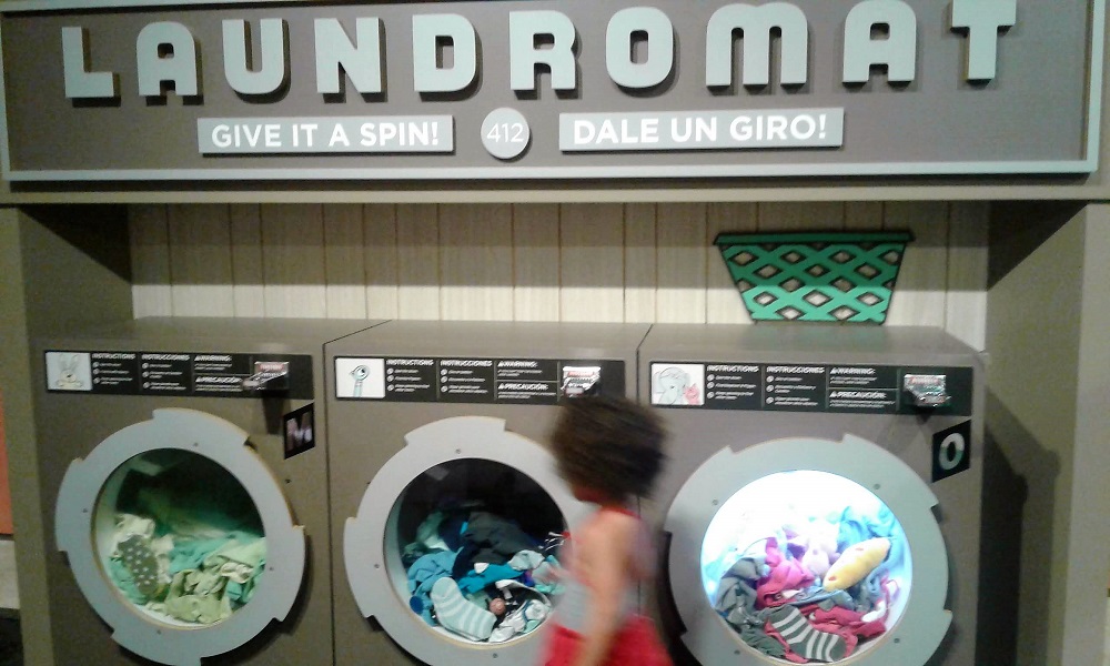 "Laundromat" display with three turnable washing machine fronts full of soft objects