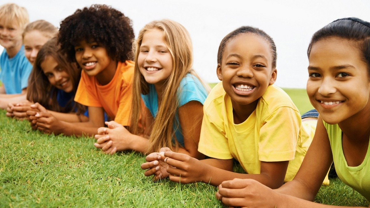 A line of smiling children of various ethnicities