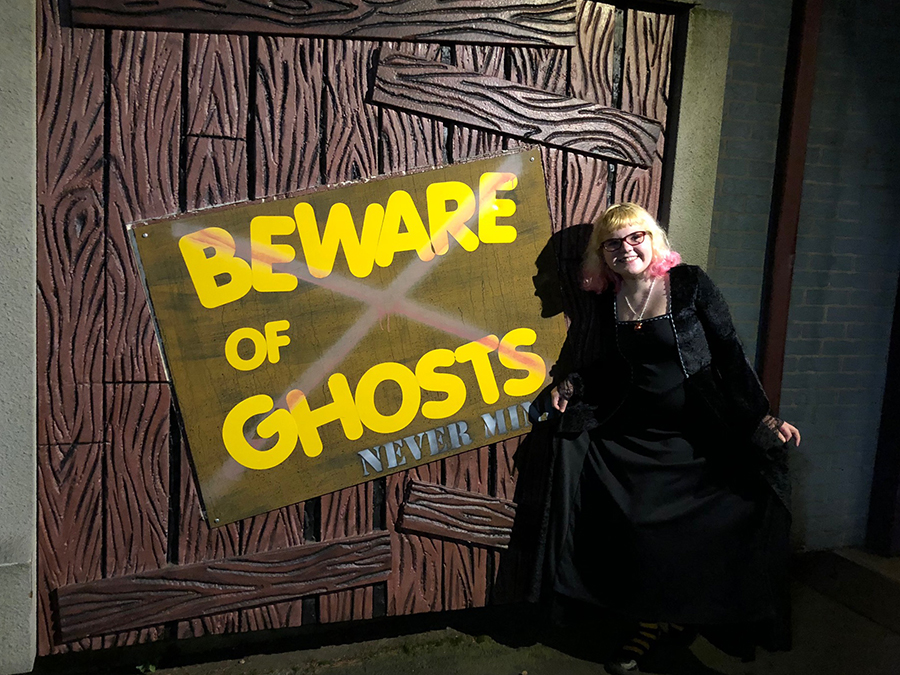 a photo of the author's daughter in front of a tent stating "Beware of Ghosts"