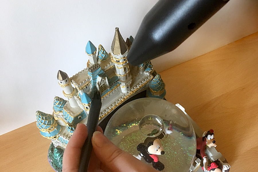 Using a brush accessory to clean an intricate snowglobe with the CompuCleaner, Image: Sophie Brown