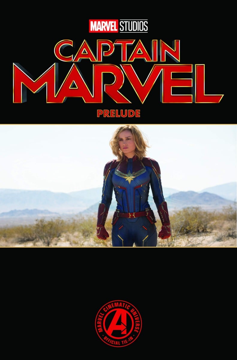 Carol Danvers in her movie costume. The words "Captain Marvel Prelude" in red against a black backgoround