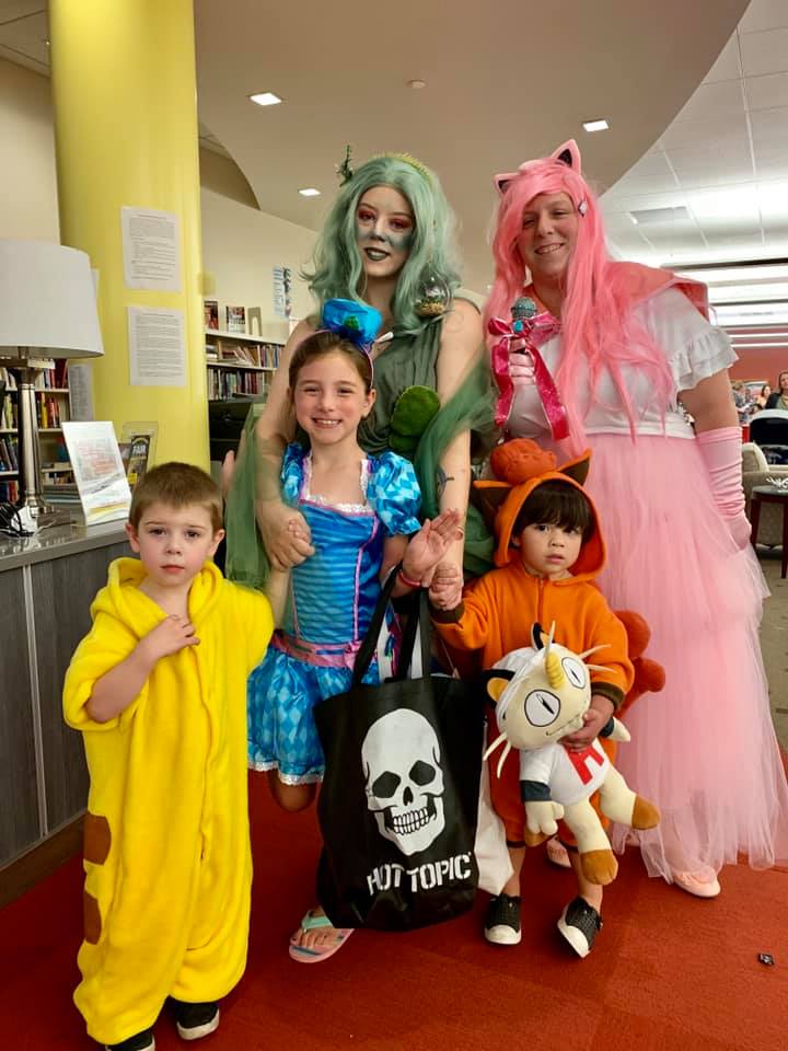 Two adults as colorful anime characters and three children of various ages in more colorful (mostly Pokemon) costumes